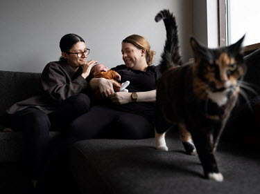 Heiour Maria Runarsdottir and Michelle Savage with their first child four days after it was born on 13 December 2021 as their cat Annabella roams nearby. According to tradition, the baby's name, Atlas...