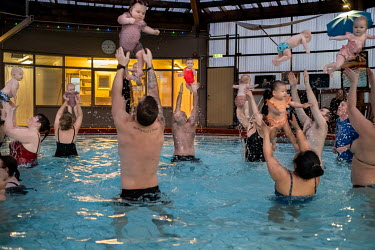 Parents throw their babies into the air at a parent and baby swimming class. Snorri Magnusson started giving swimming lessons for babies in 1990. Currently he teaches up to three lessons a day, six da...