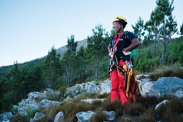Wearing her heavy climbing gear and carrying a first aid kit, Khanyisa Mzayifani, a Rope Technician on a high-angle tree clearing team, jokes with her colleagues as she waits for them to catch up as t...
