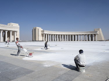 Workers filling gaps between the tiles at the newly built Arc de Triomphe in Egypt's New Administrative Capital.  Following persistent problems of overpopulation, pollution and traffic congestion, the...