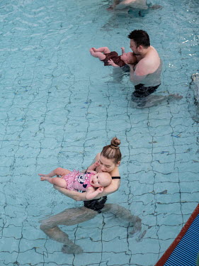 Parents with their babies in a swimming pool at a session run by Snorri Magnusson who started giving swimming lessons for babies in 1990 although he says swimming is just a minor part of his teaching,...