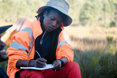 Zikhona Gcakamani, leader of a high-angle tree clearing team, preparing for a pre-dinner team meeting at her team's campsite in a remote montane catchment area that feeds the Theewaterskloof dam. The...