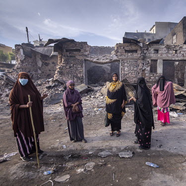 A group of women stand among charred remains of the Waheen market after a huge fire tore through what was home to an estimated 2,000 shops and stalls. According to officials about two dozen people wer...