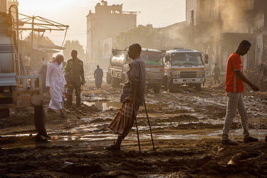 People at a road junction that has been churned to mud by emergency service vehicles which attended a huge fire at the Waheen market that was home to an estimated 2,000 shops and stalls. According to...