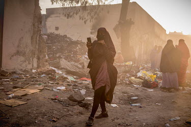 A woman walks among charred remains after a huge fire tore through the Waheen market, home to an estimated 2,000 shops and stalls. According to officials about two dozen people were injured and hundre...
