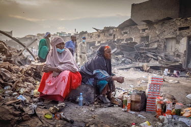 Stall holders sit among charred remains after a huge fire tore through the Waheen market, home to an estimated 2,000 shops and stalls. According to officials about two dozen people were injured and hu...