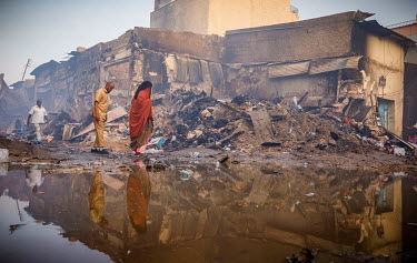 People walk among charred remains after a huge fire tore through the Waheen market, home to an estimated 2,000 shops and stalls. According to officials about two dozen people were injured and hundreds...