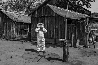 Paulo Marcos Tupxi, an indigenous Manoki man, removes his beekeeper's suit after collecting honey from his apiary on Irantxe Indigenous Land. Without many income alternatives, the Manoki people have b...