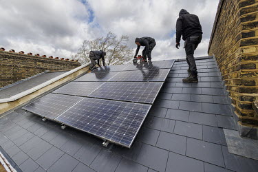 Workers installing solar photovoltaic (PV) panels on an 1890s terraced house in Southwark.