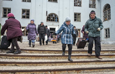 Elderly men and women rush to a minibus from the House of Culture, where they have been waiting for the transport out of the city. Transport to evacuate the people was organised by volunteers from SOS...