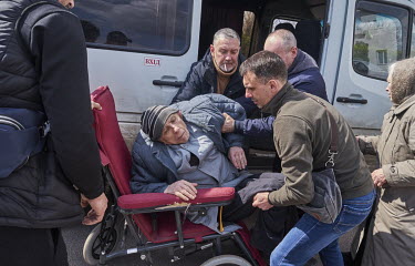 Volunteers help a man in a wheelchair, who was evacuated from the Donetsk region, out of a minibus. He will stay with his family overnight at the Good News Church (Dobraya Vest) and leave the next day...