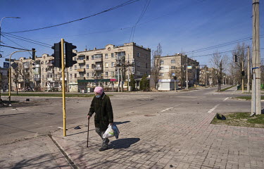 An elderly woman walks on an empty street in Severodonetsk.