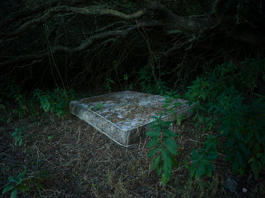 A mattress abandoned in undergrowth near a beach where migrants often land after crossing the Mediterranean from north Africa.