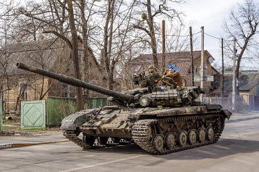 Ukrainian soldiers driving a tank through Irpin after the town was retaken from Russian forces.
