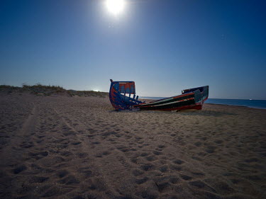 A full moon shines over an abandoned boat on a beach near the village of Vejer de la Frontera where migrants often land after crossing the Mediterranean from north Africa.
