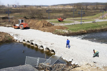 A construction worker walks across a newly constructed temporary bridge over the River Irpin (Irpen) following the re-occupation of the commuter town by Ukrainian forces.