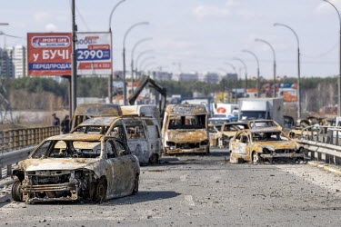 The rusted chassis of burned out cars left on a road beside the river Irpin (Irpen) bridge after the foiled Russian advance on the capital.