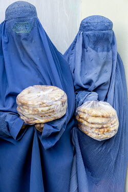 Women gather for bread at a distribution point where the Yesevi Social Central Association provides food aid to people in need.