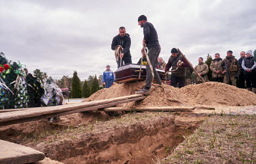 The coffin is lowered into the ground during the funeral of soldier, Zhenya Pasechnik (41), who was killed during shelling on 6 March 2022 in Irpin. His mother (Natasha) said her son was buried in fro...
