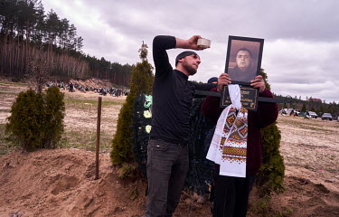 A picture of soldier, Zhenya Pasechnik (41), who was killed during shelling on 6 March 2022 in Irpin, is attached to the cross at his grave during his funeral. Natasha, his mother, said her son was bu...