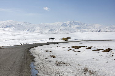 Snow covers the land around a road on the route between Kabul and Bamyan.