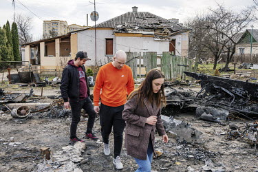 Local residents walk past houses damaged during fierce fighting between the invading Russian army and the Ukrainain Defence Forces in Bucha.