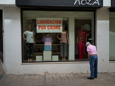 A man looks for offers in a store that its about to permanently close in downtown Ceuta.