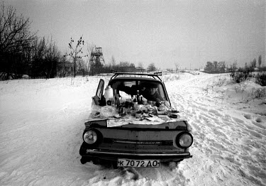 With the temperature outside dropping to minus 15C, a family sit in their Zaporozhets 968M to keep warm. Their New Year's Day picnic is spread out on the bonet of the Ukrainian-built vehicle that was...