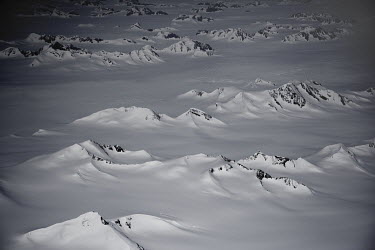 An aerial view of the snow capped peaks that form the Greenland ice sheet.