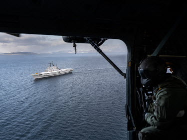 A helicopter flight crew looks down at the Italian aircraft carrier Giuseppe Garibaldi during 'Cold Response 2022' (CR 22), a Norwegian military exercise involving invited allies and partner nations h...