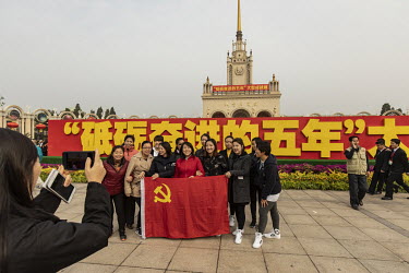 Visitors have their pictures taken while holding a Chinese Communist Party flag at the 'Five Years of Sheer Endeavour', a showcase on the achievements of the Chinese Communist Party and President Xi J...