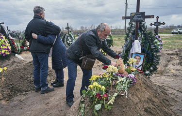 The father of Rudenko Denis Oleksandrovich (38) places a loaf of bread on his son's grave during his funeral. Denis used to be a member of Anti-Terrorist Operation (ATO), and when Russian Forces attac...