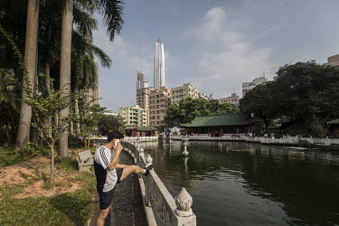 A man does some stretches while talking on a smartphone in a park in Huanggang village in Shenzhen. Several villages, including Huanggang, formed much what became the Shenzhen special economic zone in...