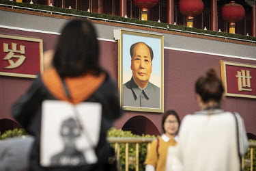 Visitors stand in front of Chairman Mao's portrait in Tiananmen Square during the Chinese Communist Party's congress in the Great Hall of the People.