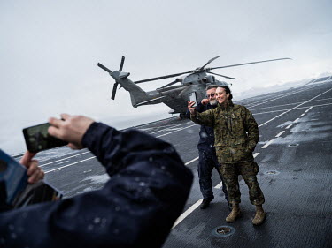 Marcello Grivelli takes a selfie on the flight deck with U.S. Marine Corps 1st Lt. Stephanie Baer, in a sudden snowstorm on board Italian aircraft carrier Giuseppe Garibaldi during 'Cold Response 2022...