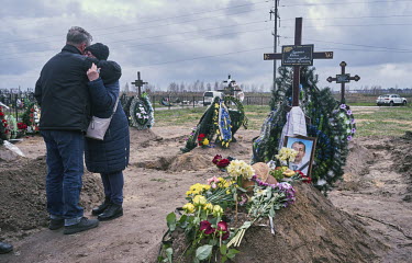 The parents of Rudenko Denis Oleksandrovich (38) embrace beside his grave during his funeral. Denis used to be a member of Anti-Terrorist Operation (ATO), and when Russian Forces attacked Ukraine he w...
