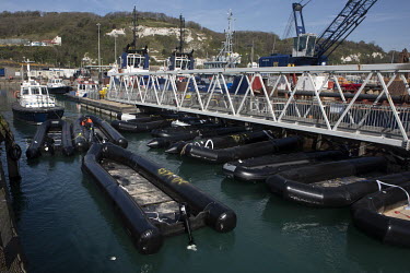 Flimsy inflatable boats used by migrants to cross the English Channel, are collected in Dover Harbour.