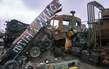 Wrecked Russian army vehicles, destroyed by the Ukrainian Army, dumped on the outskirts of Irpin. A text on the tank reads: 'Putin cocksucker'.