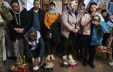 Doctors and nurses from the National Clinical Center of the Ministry of Defense of Ukraine wait for their baskets of food, bread (pascha), eggs, meat and sausages, to be blessed by a priest at the Chu...