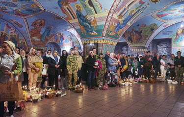 Doctors and nurses from the National Clinical Center of the Ministry of Defense of Ukraine wait for their baskets of food, bread (pascha), eggs, meat and sausages, to be blessed by a priest at the Chu...