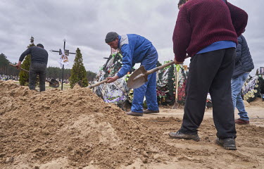 Cemetery workers fill in the grave of Zhenya Pasechnik (41), a Ukrainian soldier who was hit during the shelling on March 6, 2022 in Irpin. His mother (Natasha) said her son was buried in front of the...