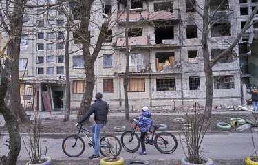 A boy and a man look at a destroyed apartment block in the Obolon district. It was hit by a Russian shell in the early morning hours of 14 March 2022 killing two people and wounding many more.