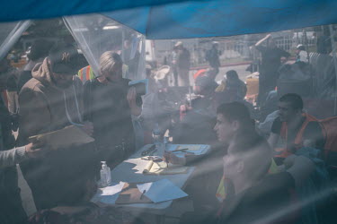 Volunteers organise lists of Ukrainian refugees waiting to cross into the United States at an improvised camp near the San Ysidro border crossing. Volunteers, many of them Ukrainians living in the Uni...