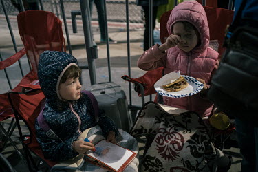 Ukrainian children play and eat tacos while they wait to enter the United States at the San Ysidro border crossing. Volunteers, many of them Ukrainians living in the United States have helped establis...