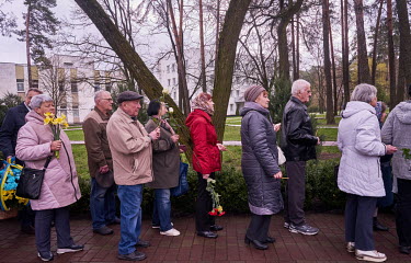 Chernobyl veterans, holding flowers, queue, on the 36th anniversary of the Chernobyl disaster, to visit the Chernobyl Memorial which is dedicated to the firefighters and workers who went, ill-equipped...