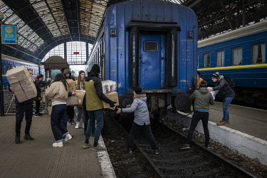 Young volunteers rush to load humanitarian aid onto a train bound for the east of Ukraine.