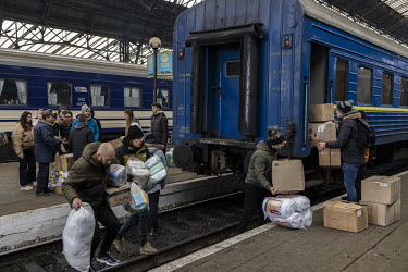 Young volunteers rush to load humanitarian aid onto a train bound for the east of Ukraine.