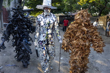 'L'homme miroir' by Patrick Kitete walking with The Coconut Man, who fights against deforestation, and The Rubber Man, artist Kilomboshi Lukumbi Henock, aka Pape Noire, together near 'la vie est belle...