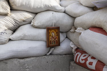 An icon hangs from sandbags inside a checkpoint on the outskirts of Lviv.