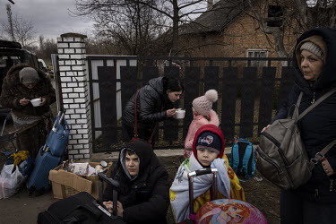A family from Odessa take a break to eat some food and rest before joining the long queue waiting to cross into Poland. A crowd of several thousand or more, mainly women and children, queued up in the...